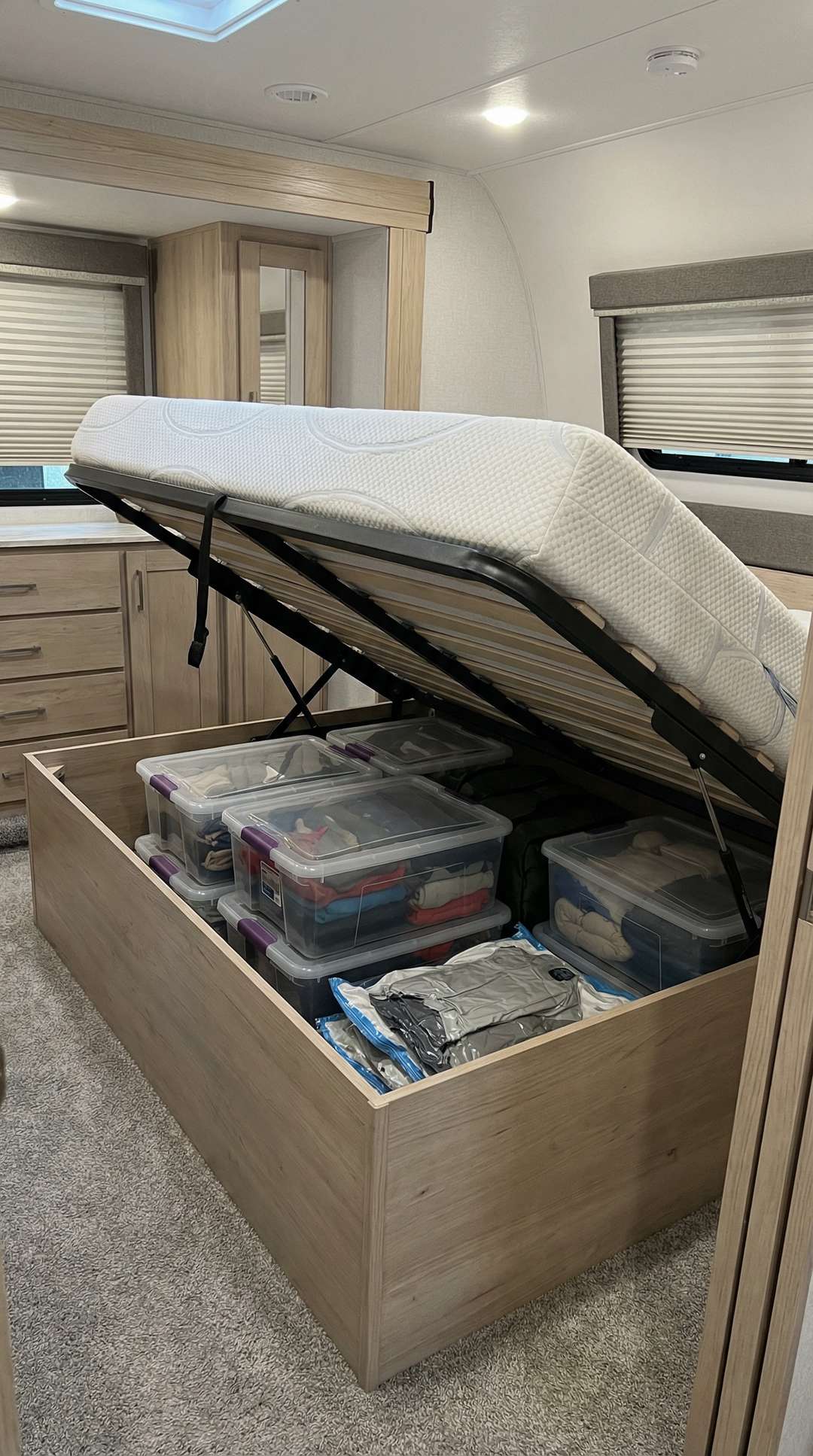 Under-bed storage with rolling containers in RV bedroom