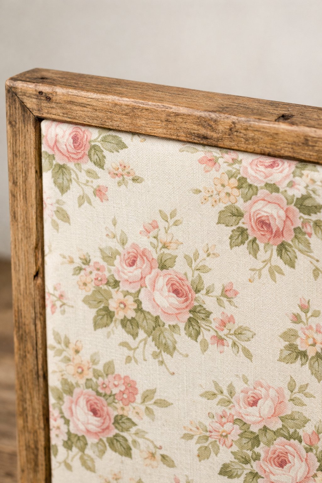 A piece of floral fabric stretched tightly over a rustic wooden frame.
